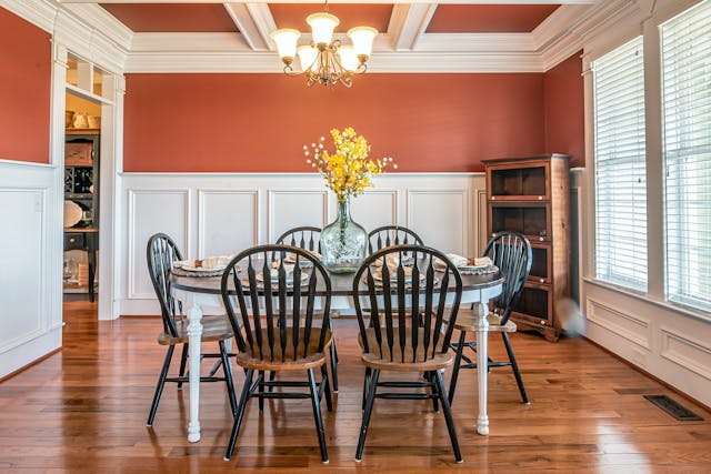 An orange and white dining room with a dark wood table